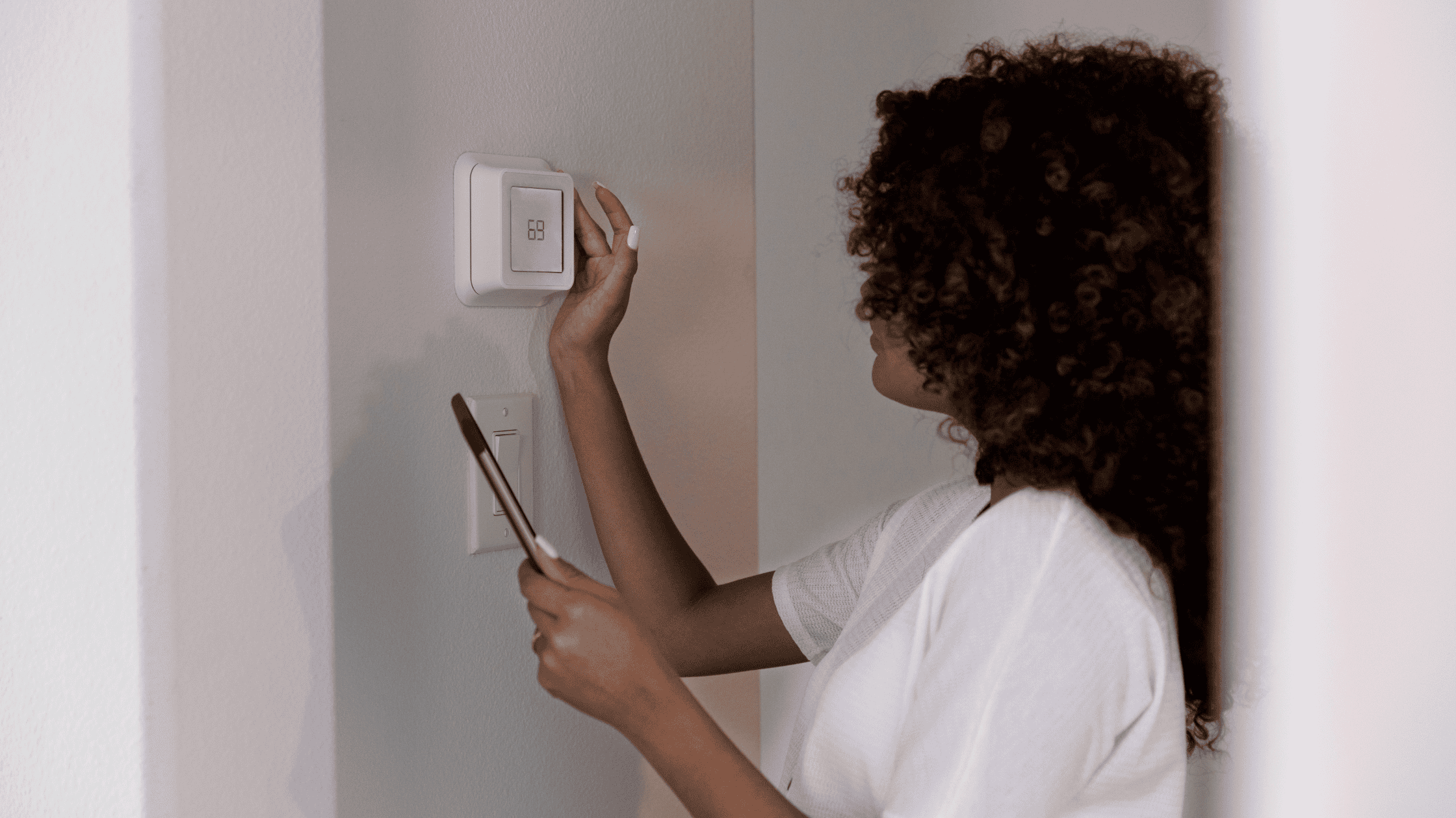 a person is adjusting the temperature on an energy-efficient hvac thermostat