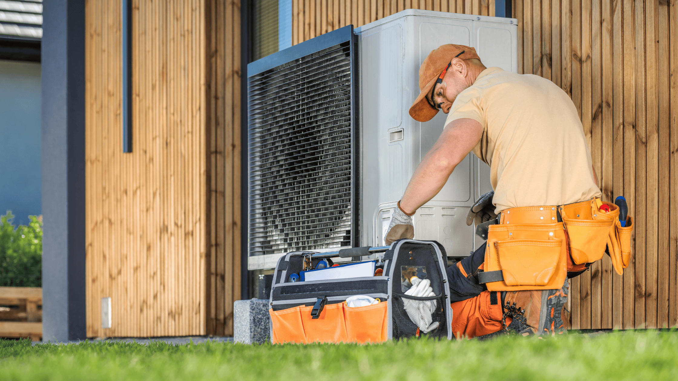 a person working on an air conditioner in front of a house